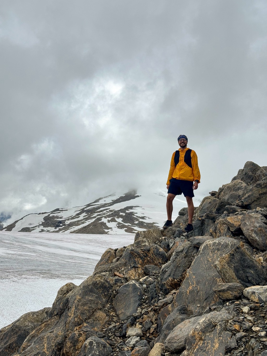 Croix standing on a rocky ridge above a glacier in the mountains